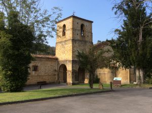 Vista parcial del monasterio de San Pedro de Villanueva, donde se ve la entrada ajardinada con un grandioso tejo en un lateral