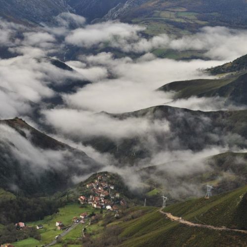 Vista de Arangas de Cabrales desde los montes que lo rodean, al fondo, parcialmente cubierto por la niebla, vemos el resto del valle